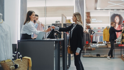 Clothing Store Checkout Cashier Counter: Beautiful Young Woman Buys Blouse from Friendly Retail...