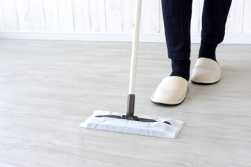 床の拭き掃除をする主婦の足元
