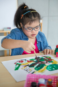 Asian girl with Down syndrome painting