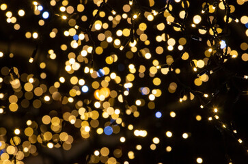 Fototapeta na wymiar Defocused lights, Christmas lights lanterns on a dark background. Christmas and New Year holiday concept