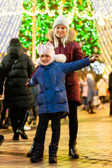 mother and daughter in front of a christmas tree at the fair