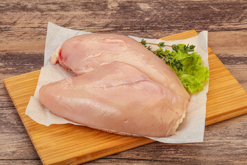 Raw chicken breast over board