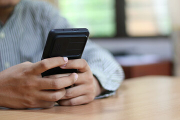 Person using a social media marketing concept on mobile phone with notification icons of like, message, comment and star above smartphone screen.