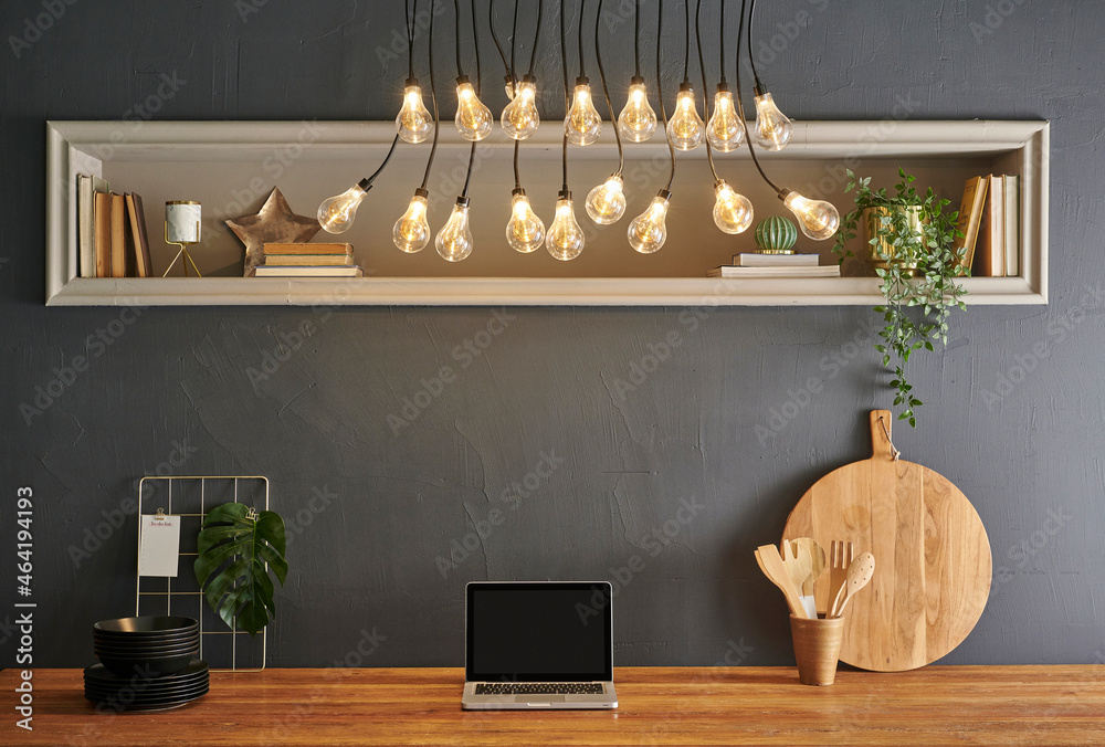 Wall mural Kitchen decoration with technological tool computer laptop, wooden table style with cutting board, knife, spoon and fork, grey stone wall.