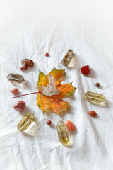 minerals and autumn maple leaf on fabric background. autumn composition. mandala for fall season....