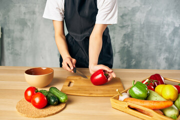 Cook woman on the kitchen cutting vegetables salad diet