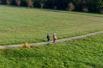 Girl and boy walking on rural road with scenic landscape on a beautiful autumn morning. Photo taken October 16th, 2021, Zurich, Switzerland.