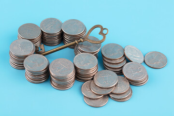 Unlocked fortune key and coins on blue background