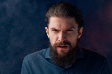 bearded man in a black shirt smoke clouds dark background