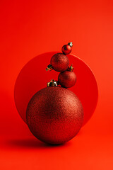 Creative Christmas layout made with shiny bauble ornaments on vibrant red background. Minimal Xmas or New Year celebration concept. Winter festive holidays composition.