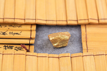 Gold nugget surrounded by bamboo slips in ancient Chinese books