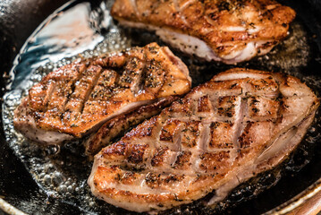 Roasted duck with a Golden crust on a black pan