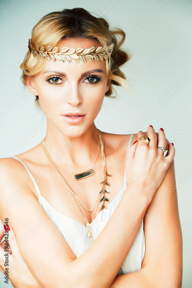 Wall mural young blond woman dressed like ancient greek godess, gold jewelry close up isolated, summer trends