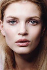 Fototapeta premium Close-up portrait of beautiful young woman with hairstyle and delicate nude makeup 