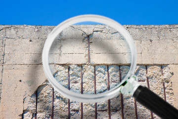 Old reinforced concrete structure with damaged and rusty metallic reinforcement that must be demolished - Concept seen through a magnifying glass