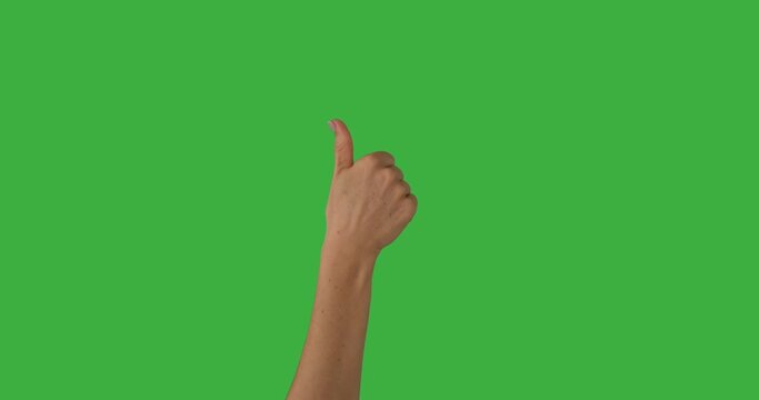 Hand of woman pointing finger and giving thumbs up gesture over green background