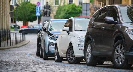 City traffic with cars parked in line on street side.