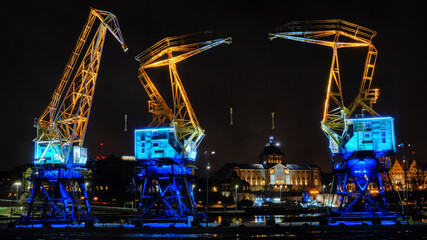 Illuminated cranes in the night - obrazy, fototapety, plakaty