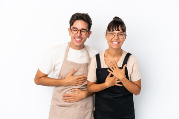 Restaurant mixed race waiters isolated on white background smiling a lot while putting hands on chest