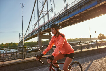 Young sporty woman in sportswear ride bicycle