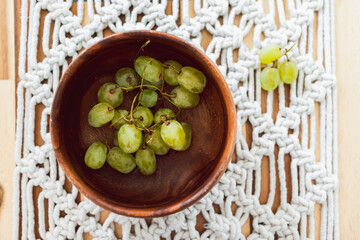 geren grapes in wooden bowl on top of wooden dining table, simple ingredients concept