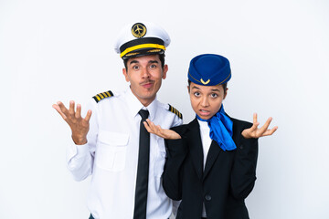 Airplane pilot and mixed race air hostess isolated on white background having doubts while raising hands and shoulders