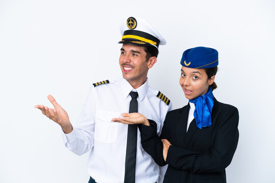 Airplane Pilot And Mixed Race Air Hostess Isolated On White Background Pointing Back And Presenting A Product