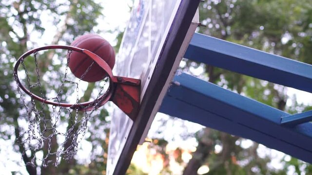 the basketball spins around the hoop and hits the target