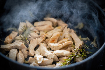  roasted turkey chopped meat in a hot pan with rosemary
