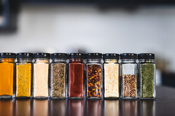 spices seeds and seasonings in mathing spice jars on tidy pantry shelf, simple vegan ingredients...