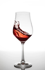 Rosé wine swirling in glass on white background 