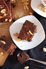 A piece of chocolate peanut brownie served with coffee. Snack or dessert table. Top view. 
