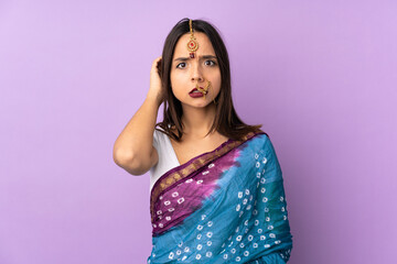 Young Indian woman isolated on purple background having doubts