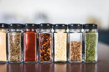 Foto op Aluminium spices seeds and seasonings in mathing spice jars on tidy pantry shelf, simple vegan ingredients and flavoring your dishes © faithie