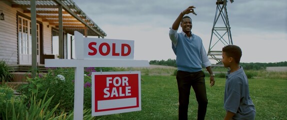 Portrait of Happy African American father teasing family with keys from their new house
