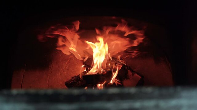 Burning firewood in a brick oven open fire for making pizza. wood burning in the stove.