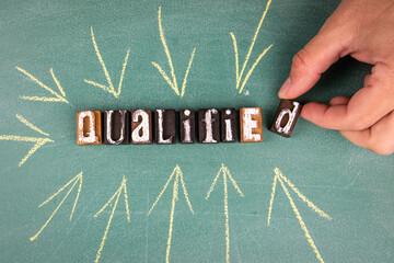 Qualified. Text with arrows on a green chalk board