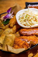 A plate of Thai snacks, fried shrimp cakes, fried spring rolls and vegetable salad