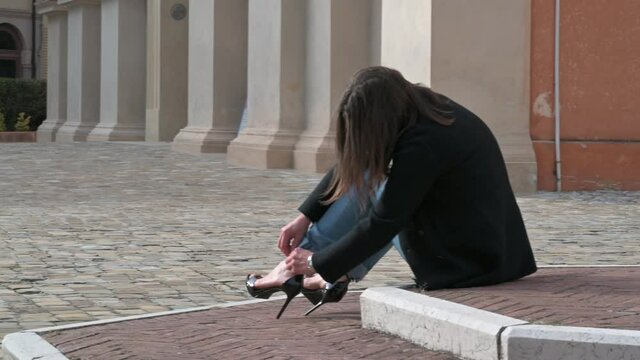 Modella seduta su selciato