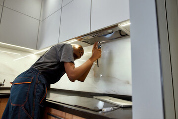 Proffesional female technician checking kitchen vent hood