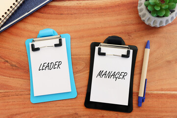 Top view image of notes with the text leader and manager. Concept of finding inspiration and motivation in management processes