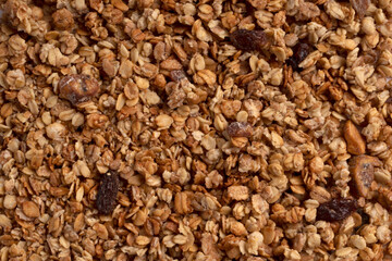 Organic granola with oats, raisins, nuts. Texture of muesli flakes as background. Top view. Blank space for text. Backplate for healthy nutrition concept. Vegetarian and vegan food for breakfast