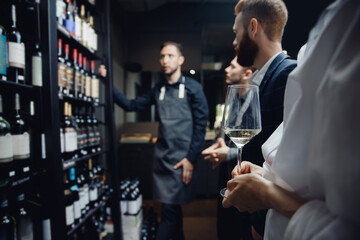 Business woman holding glass of wine while talking at party