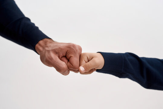 Crop of father and son give fists bump show unity
