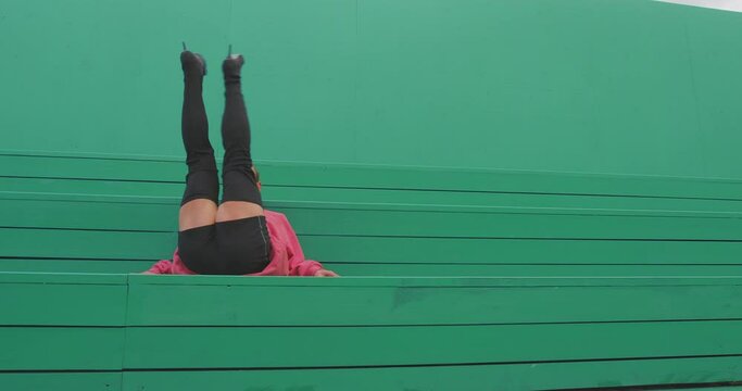 Dancing lgbt guy wearing high heels performing graceful passionate vogue femme dance on green background outside