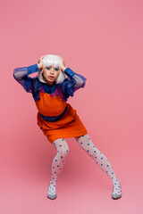 Pretty asian woman in pop art style looking at camera on pink background