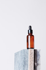 Amber glass dropper bottle with a pipette on a piece of stone. Natural cosmetics concept, natural essential oil.