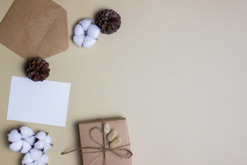 Vintage envelop with craft gift box over the brown background.