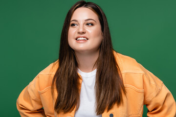 Fototapeta premium Pretty brunette woman with overweight looking away isolated on green