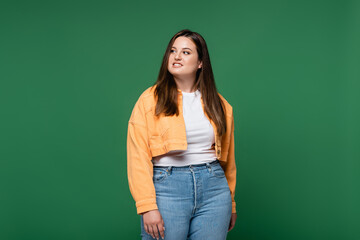 Smiling woman with overweight looking away isolated on green